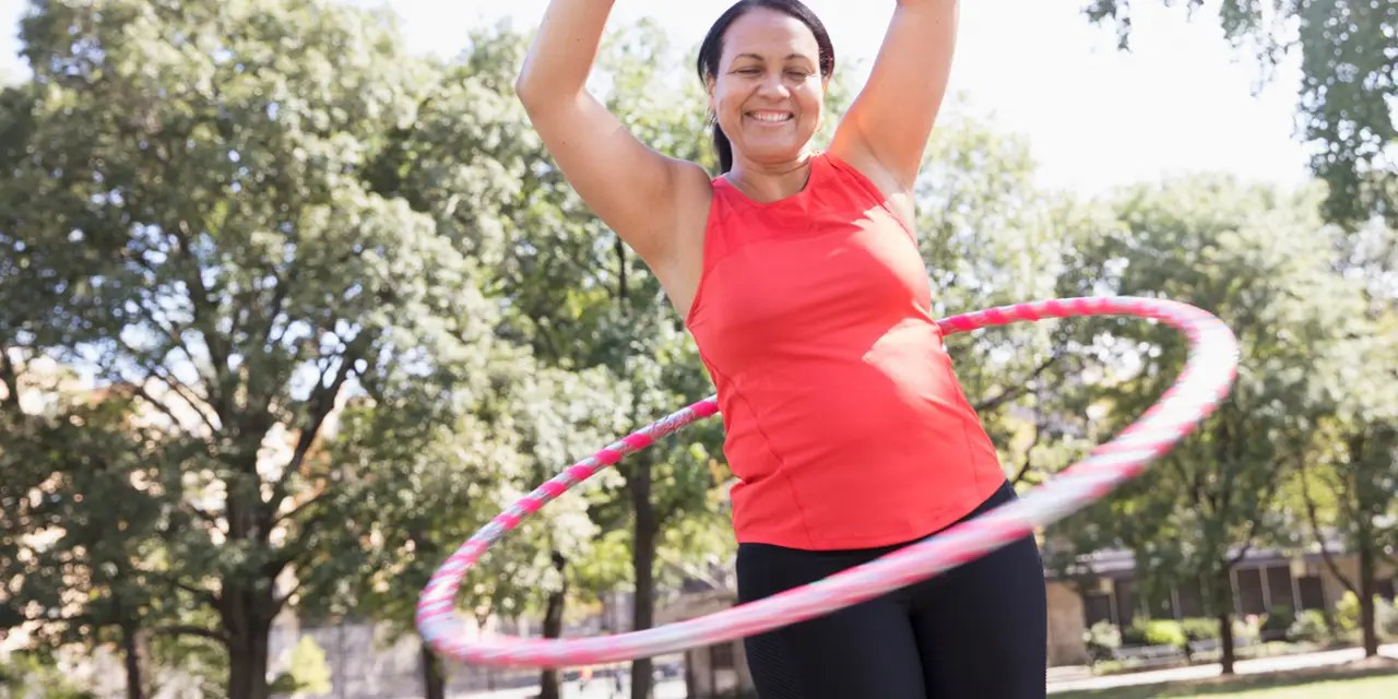 Personne faisant tourner un cerceau de hula hoop fitness autour de la taille